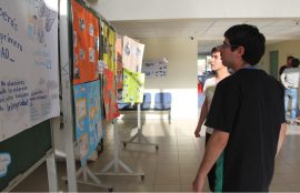 Dos estudiantes observan algunos afiches de la exposición.